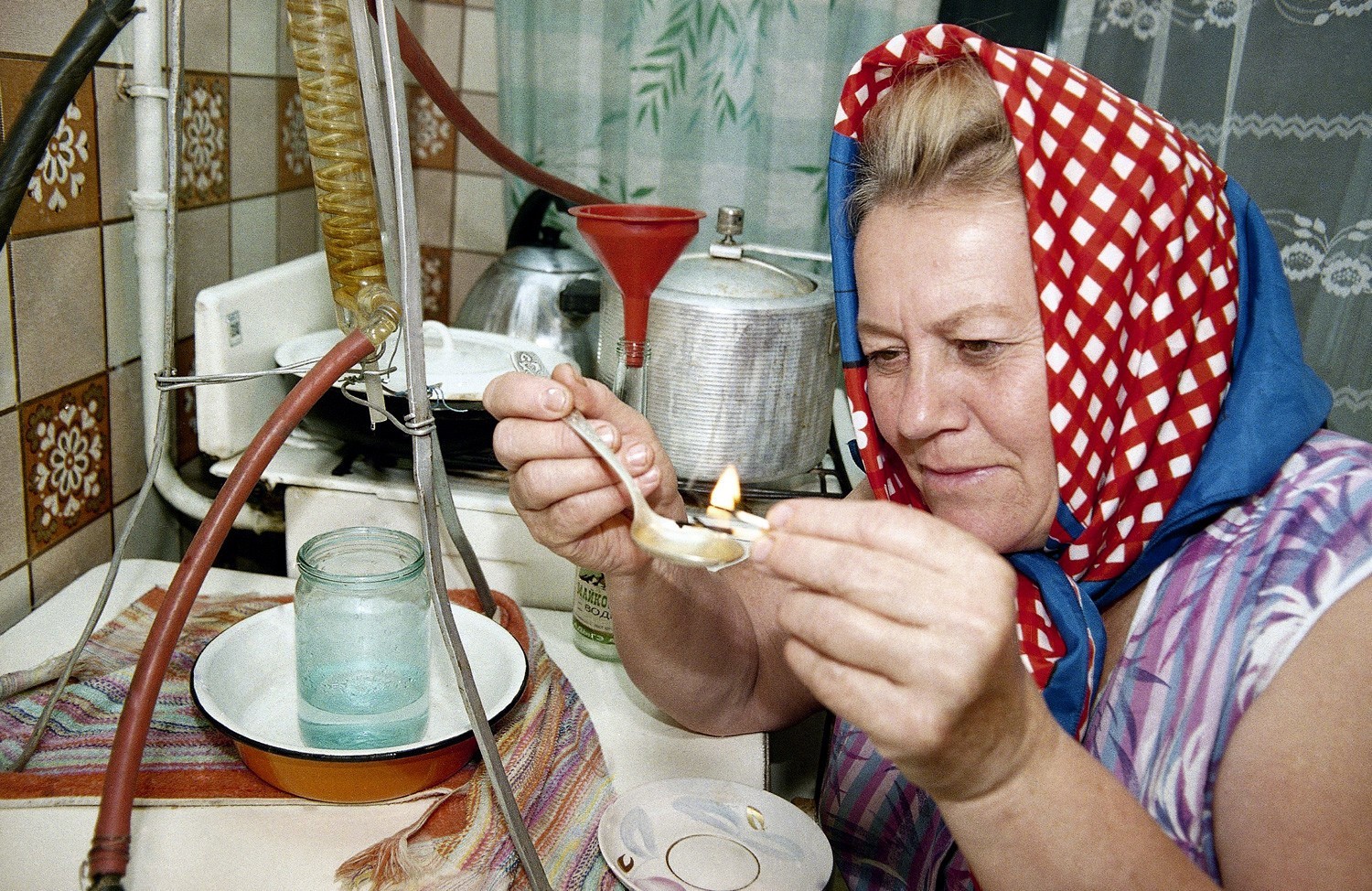 Ženska v mestu Majkop v južni Rusiji s šibico prižiga domače žganje, da bi preverila njegovo kvaliteto