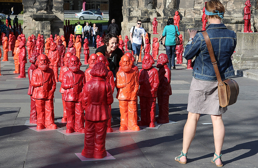 Visitors take photos with some of the 500, one meter tall statues of German political thinker Karl Marx on display on May 5, 2013 in Trier, Germany