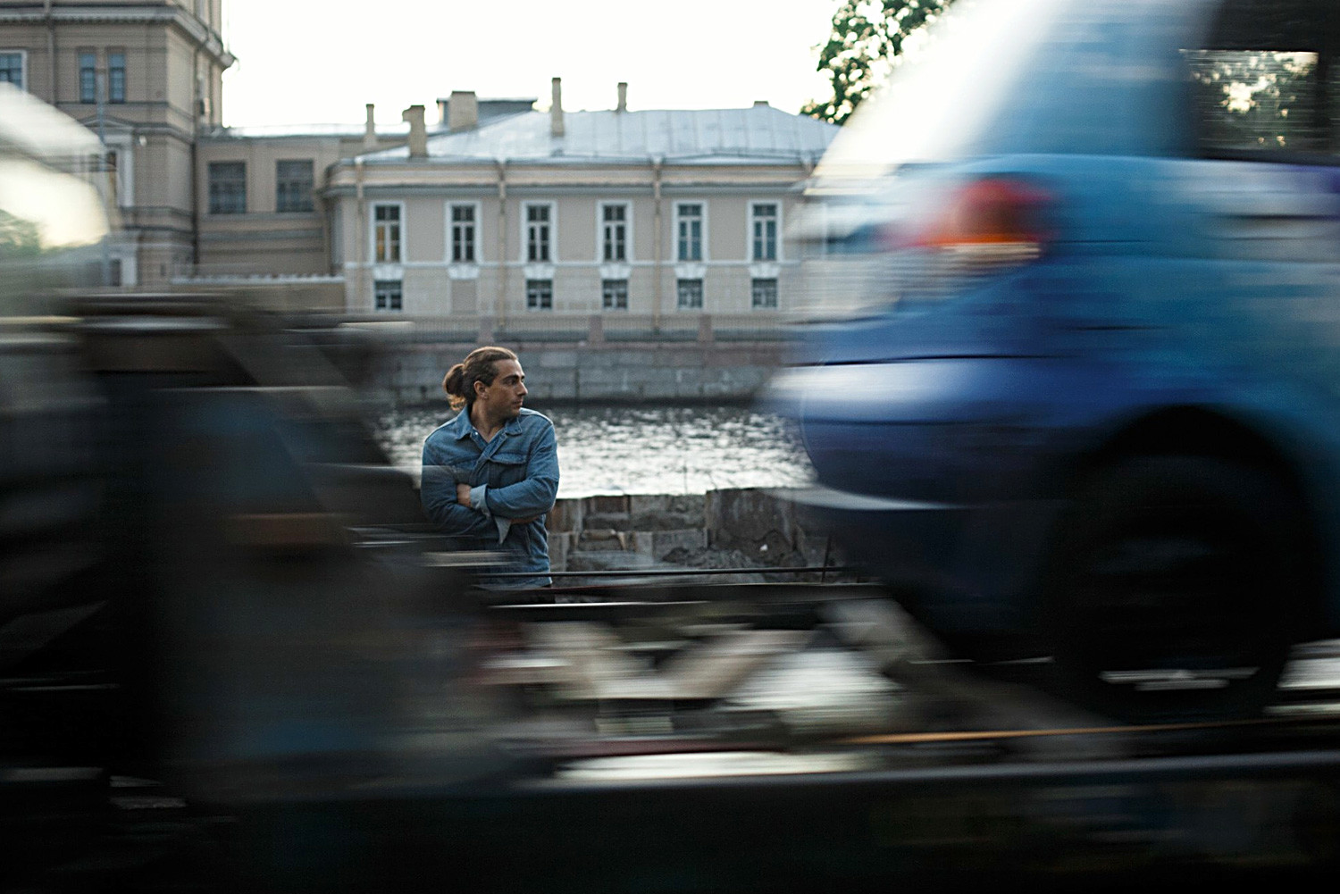 Blurred Motion Of Vehicles Against Man Standing By River Photo Taken In Saint Petersburg, Russia