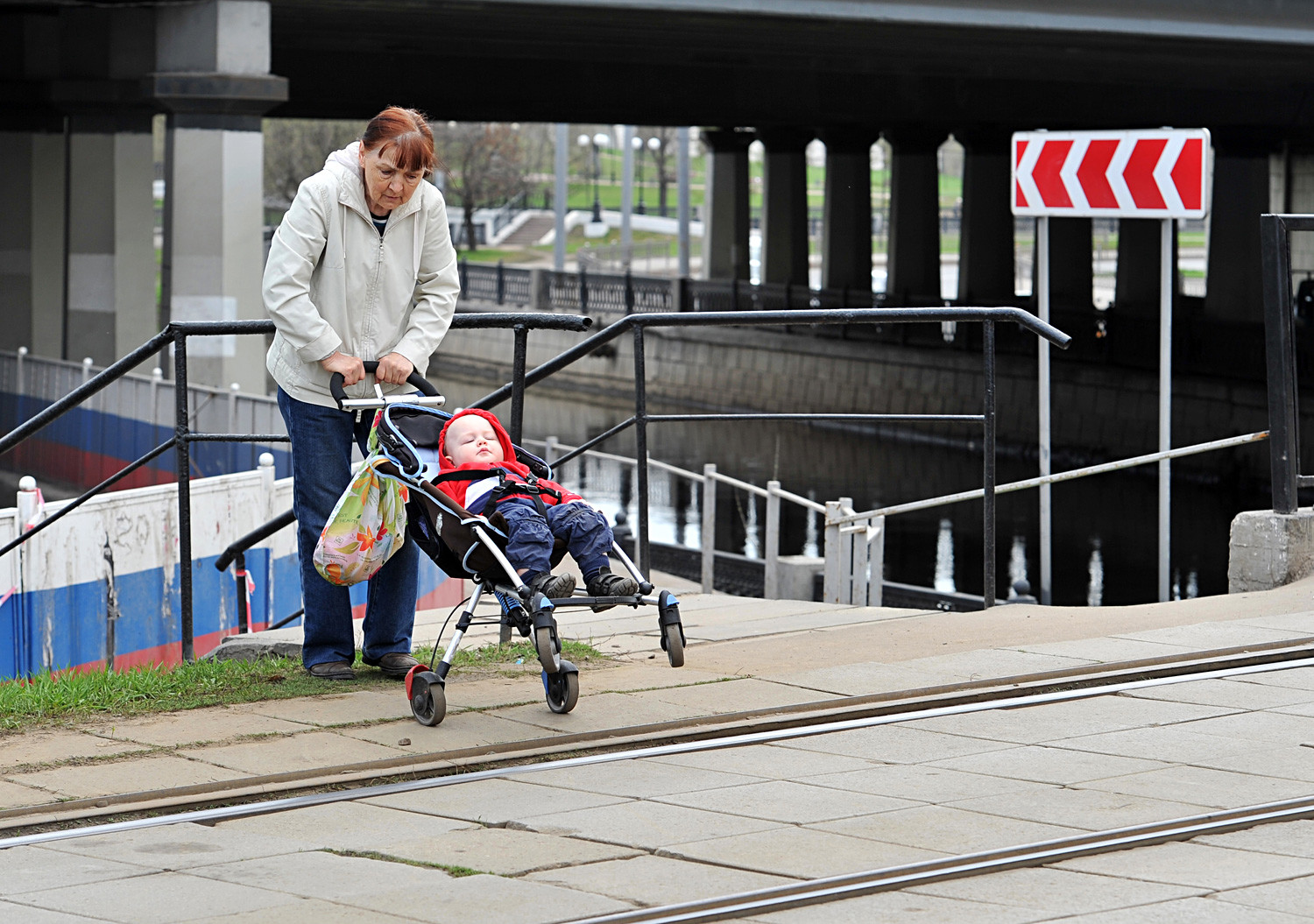 A woman with her baby crossing the street.