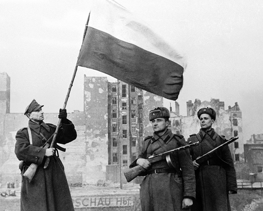 Soldados del Ejército Popular Polaco (a la izquierda) y el Ejercito soviético (derecha), ondean un bandera polaca en la Varsovia liberada, el 17 de enero de 1945.
