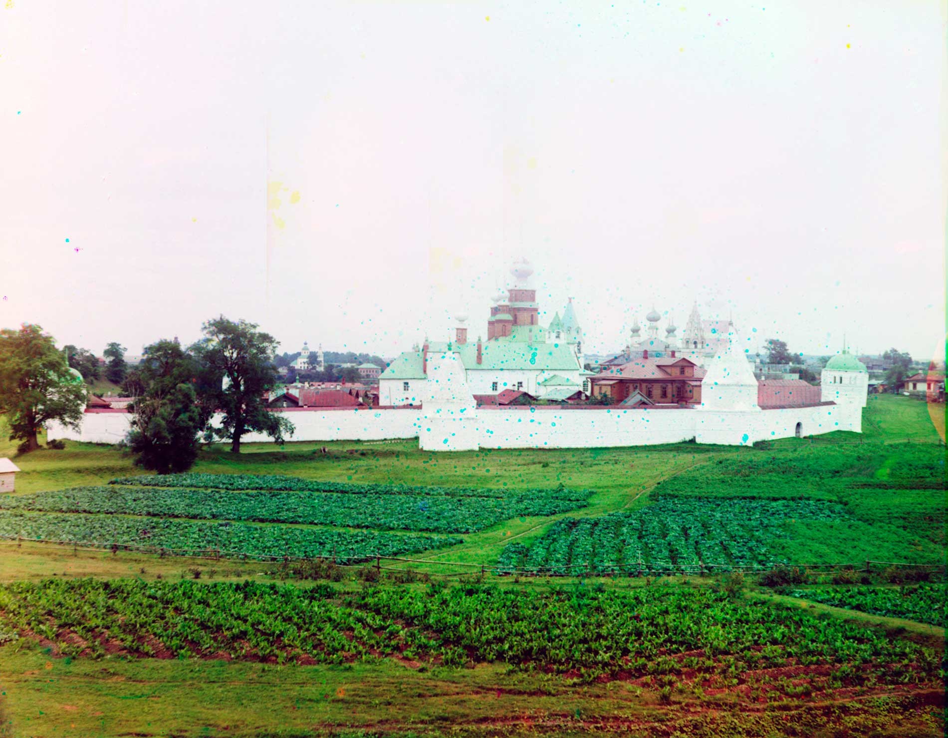 Intercession Convent, north view. Center: Church of St. Anne & ​Intercession Cathedral with three domes. Right: Church of Sts. Peter&Paul (beyond convent). Foreground: potato plots. Summer 1912