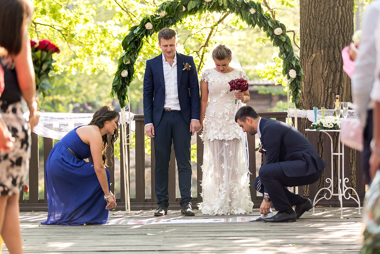 Pasangan yang baru menikah menjalankan ritus kesatuan tradisional selama upacara pernikahan.