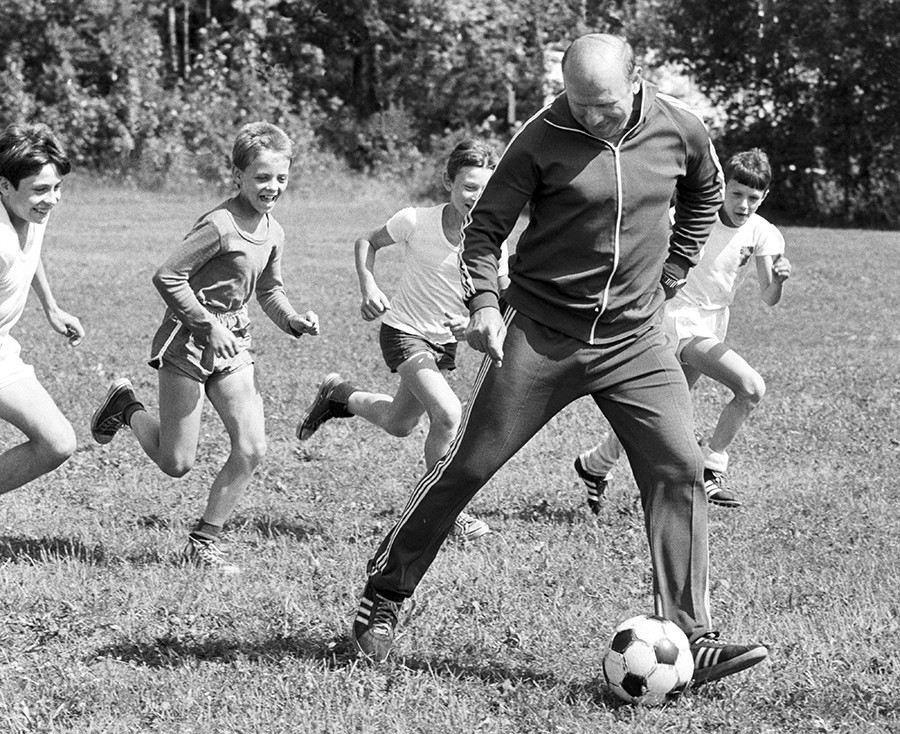 Ветеран совјетског фудбала Едуард Стрељцов (у предњем плану) игра фудбал са децом у летњем спортском кампу „Млади торпедиста“.