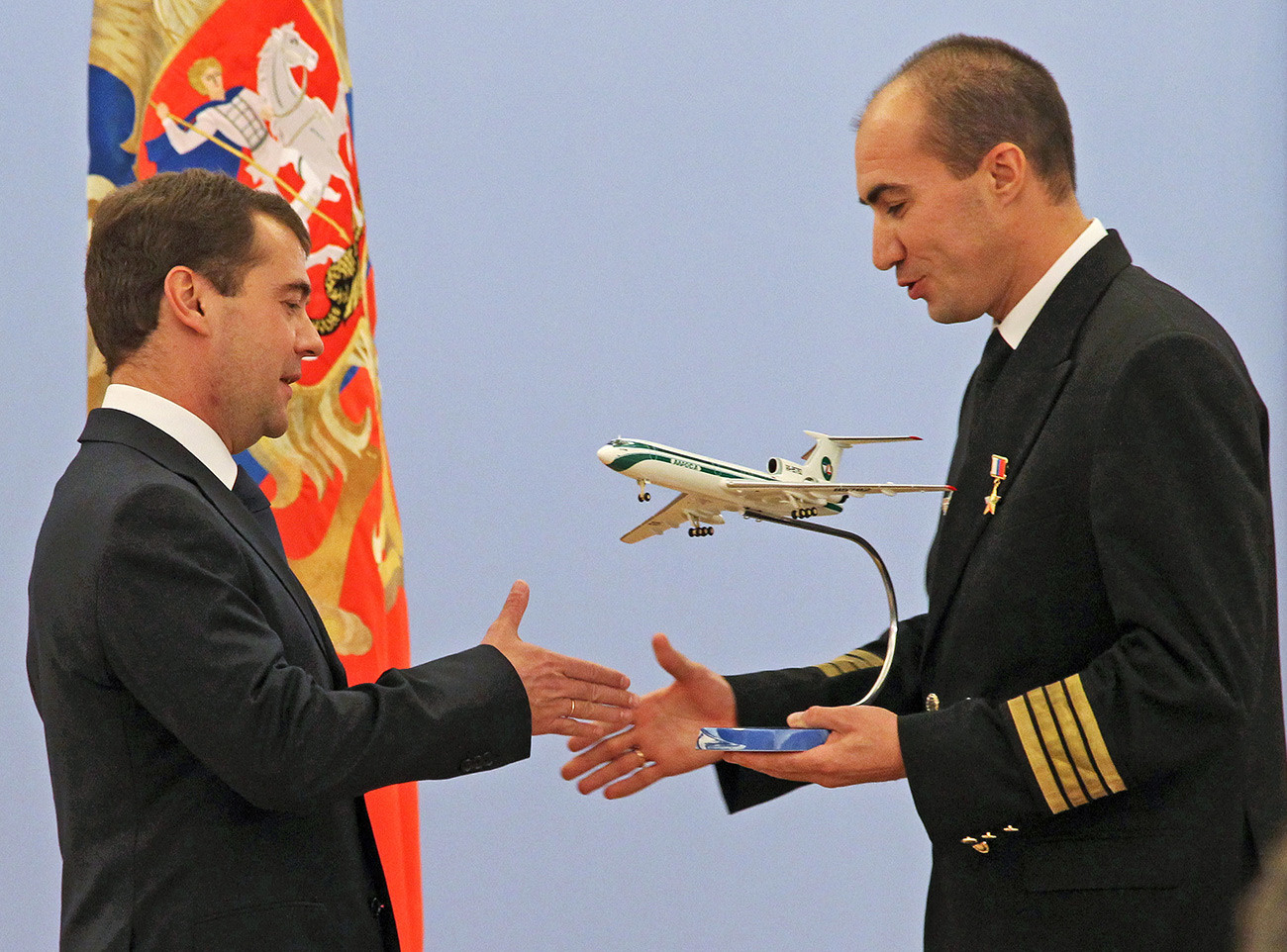 O então presidente russo Dmítri Medvédev parabeniza o capitçao do Tu-154, Evguêni Novoselov, que recebeu o título de Herói da Rússia.