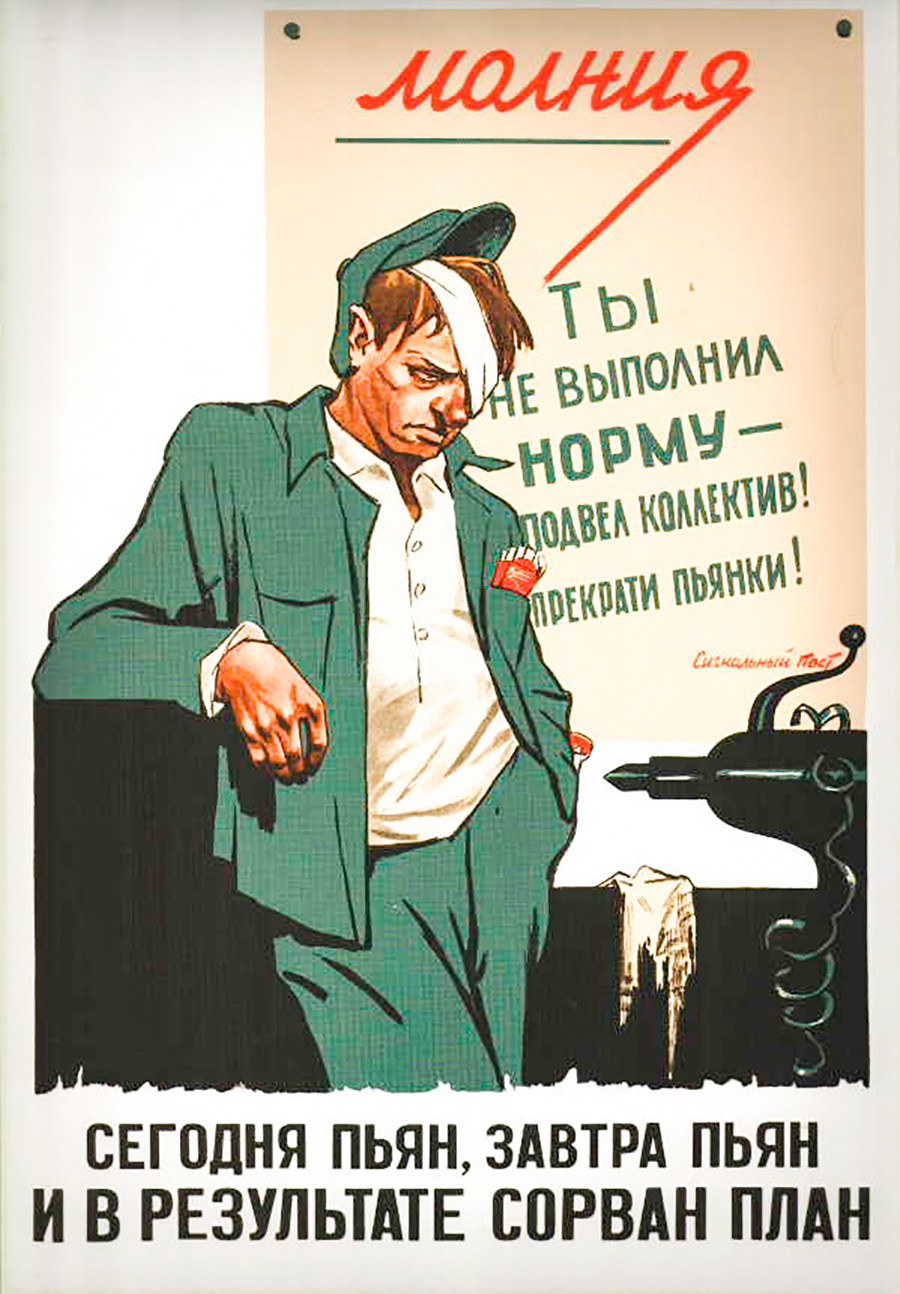 El cartel a la espalda del hombre dice: “No cumpliste con las normas de trabajo, ¡le has fallado al equipo! ¡Deja las borracheras!”. La inscripción de abajo dice: “Borracho hoy, borracho mañana, el plan de trabajo se ve interrumpido”.