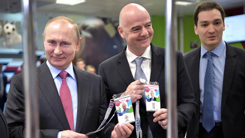 Presiden Rusia Vladimir Putin (kiri) and Presiden FIFA Gianni Infantino (tengah) mengunjungi pusat pendistribusian ‘Fan ID’ di Sochi, Rusia.