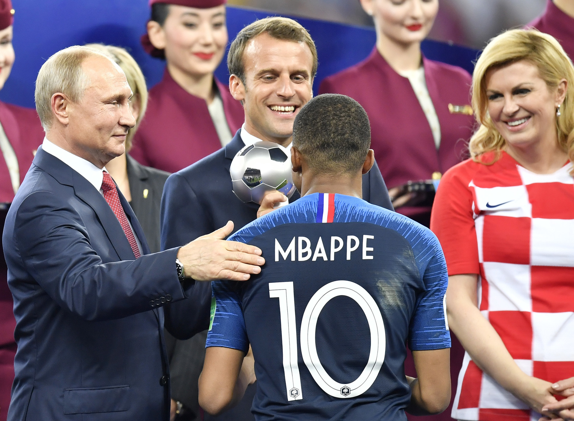 Dari kiri ke kanan: Presiden Rusia Vladimir Putin, Presiden Prancis Emmanuel Macron, dan Presiden Kroasia Kolinda Grabar-Kitarovic memberikan penghargaan kepada pemain Prancis Kylian Mbappe sebagai pemain muda terbaik setelah Prancis memenangkan Piala Dunia, Minggu (15/7).