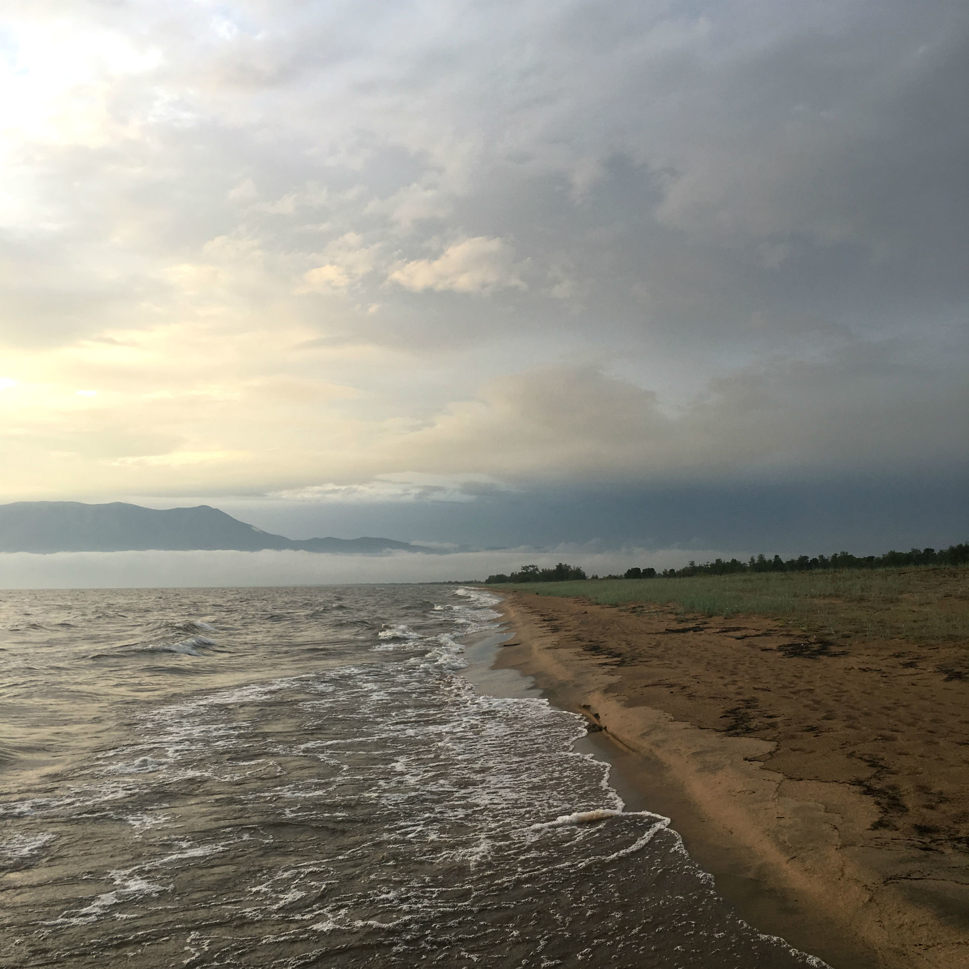 Le vaste rivage sauvage du Baïkal, à l'horizon embrumé.