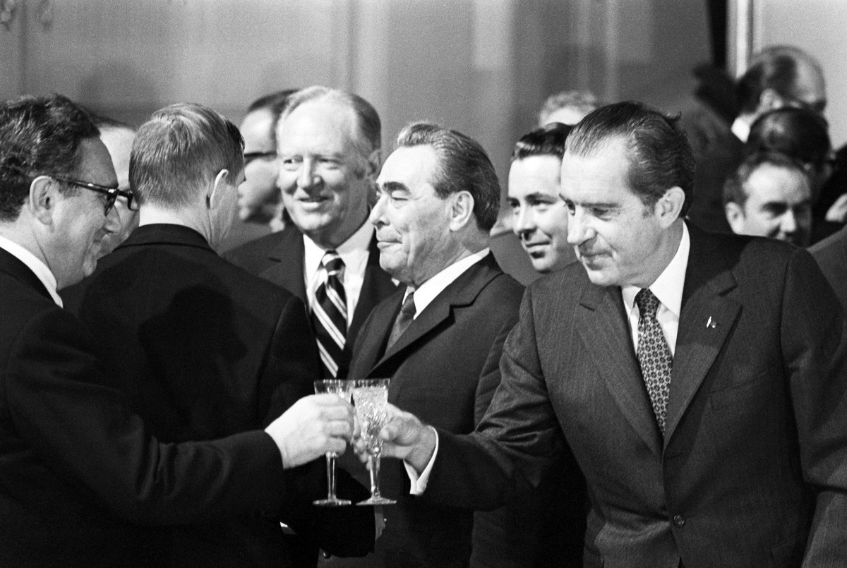 Американският президент Никсън вдига наздравица с Хенри Кисинджър в Москва през 1972 година. На фона между тях е Леонид Брежнев.
