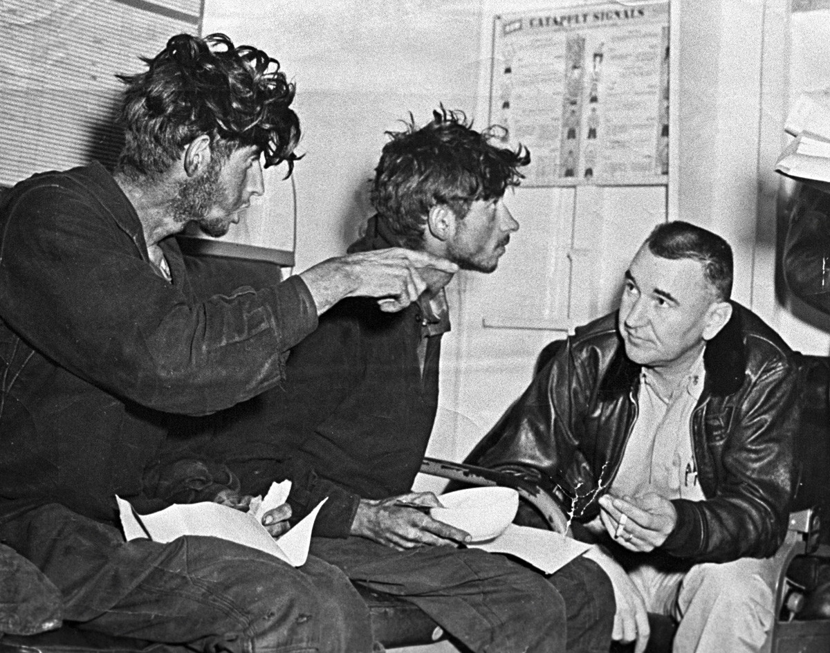 Izčrpani Filip Poplavski (levo) in Ashat Ziganšin (v sredini) pripovedujeta svoje izkušnje ameriškemu vojaku na krovu letalonosilke Kearsarge.