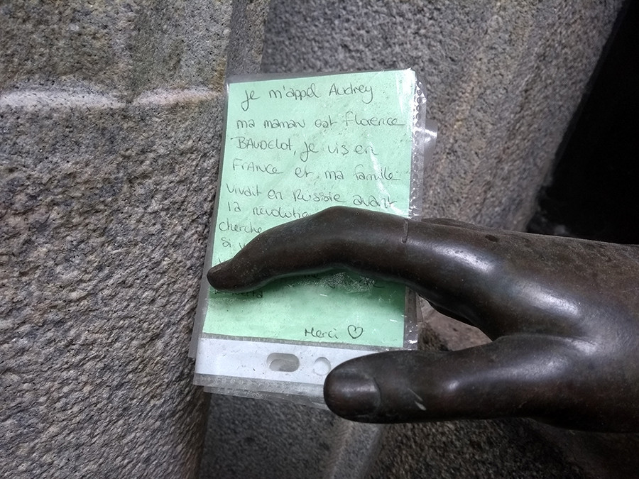 The note in the statue's hand.