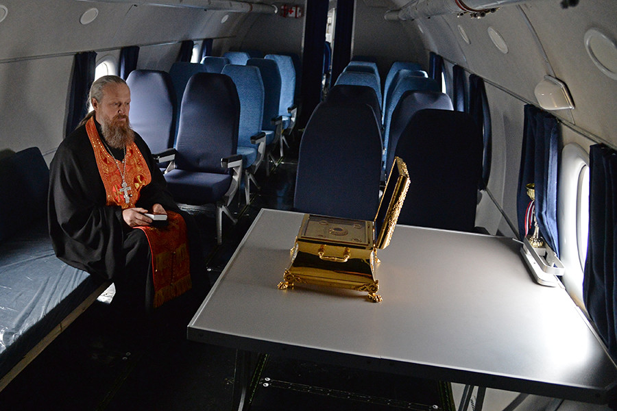 Metropolitan Nikodim of Chelyabinsk and Zlatoust during a service by the icon of St.George and his holy relics on board an aircraft. 