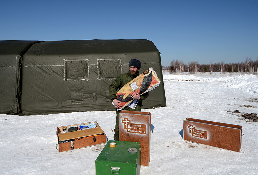 A chaplain near a mobile church set up at a landing spot, during a field airborne training exercise for military chaplains in the Ryazan region. 