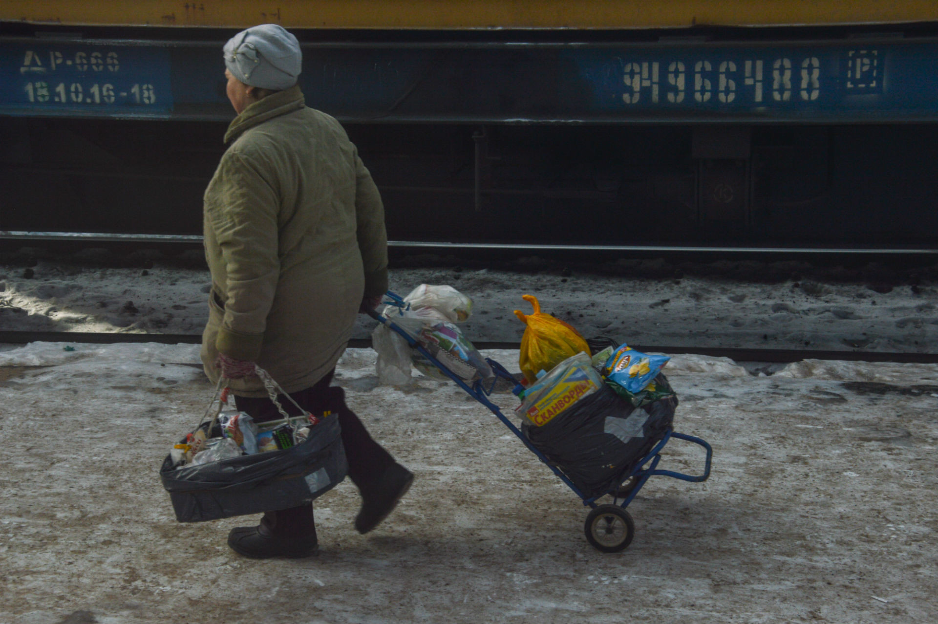 Una babushka si prepara a vendere la sua merce ai passeggeri del prossimo treno
