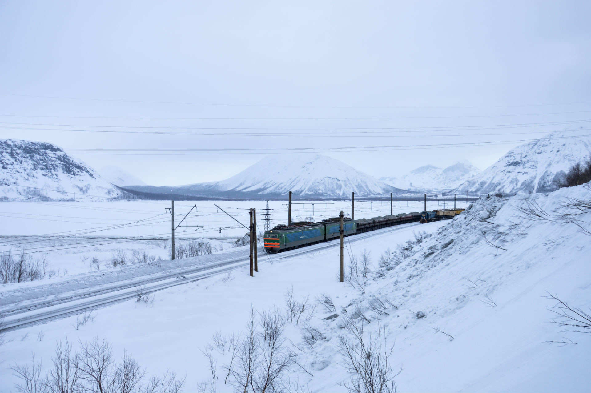 Un treno merci carico di minerali si snoda sui binari
