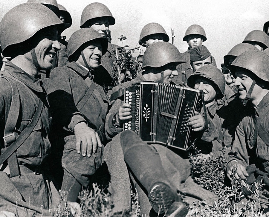 U trenucima predaha vojnici slušaju suborca harmonikaša Pantahova

