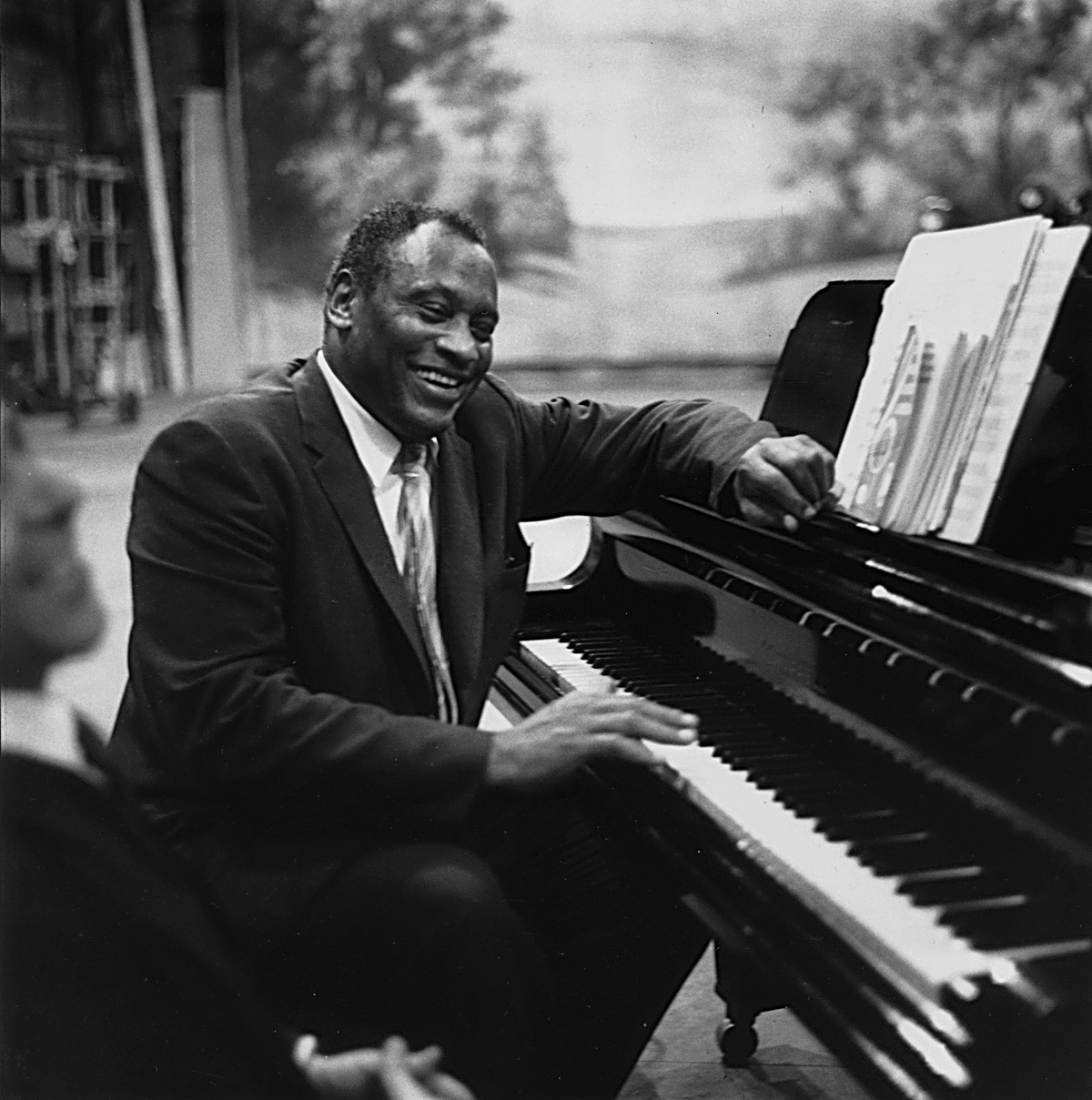 22nd July 1958: American singer, acclaimed actor of stage and screen, political activist and civil rights campaigner Paul Robeson (1898 - 1976), rehearses in relaxed mood at the piano