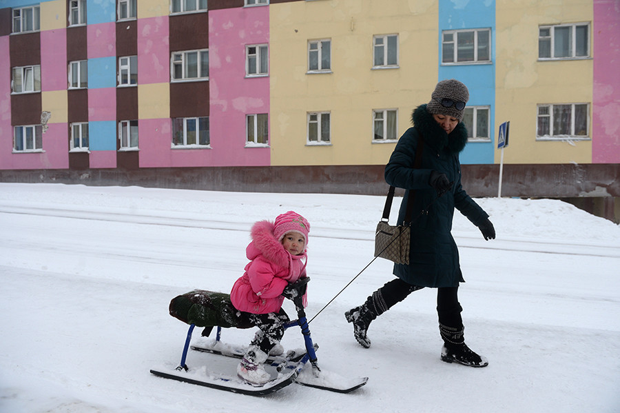 Seorang wanita dengan seorang anak di jalanan Anadyr. November 2013. 