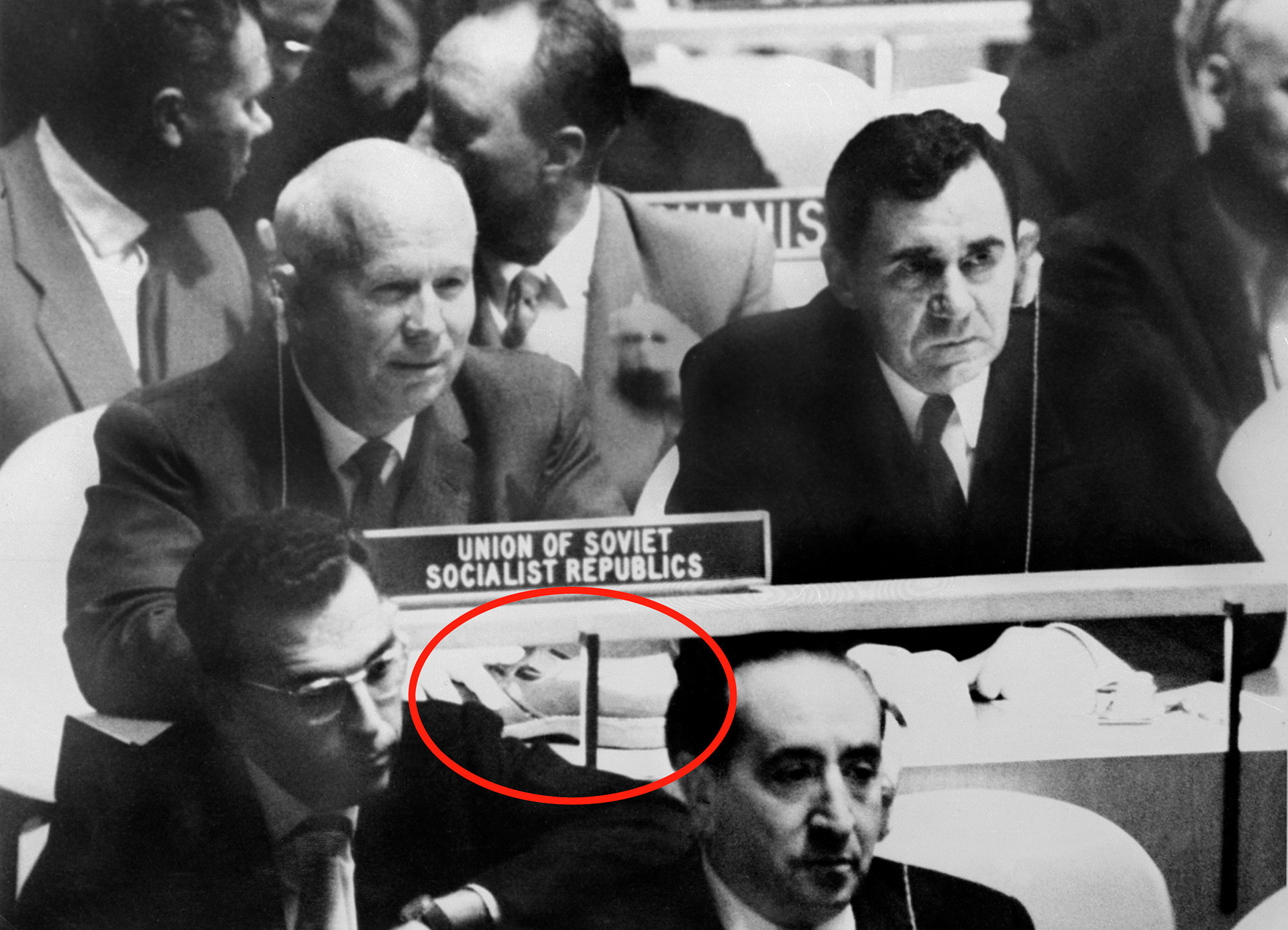 Foto verdadeira de Khruschov com o ministro dos Negócios Estrangeiros soviético Andrêi Gromiko (dir.) na Assembleia da ONU; círculo vermelho destaca sapato do líder soviético sobre a mesa