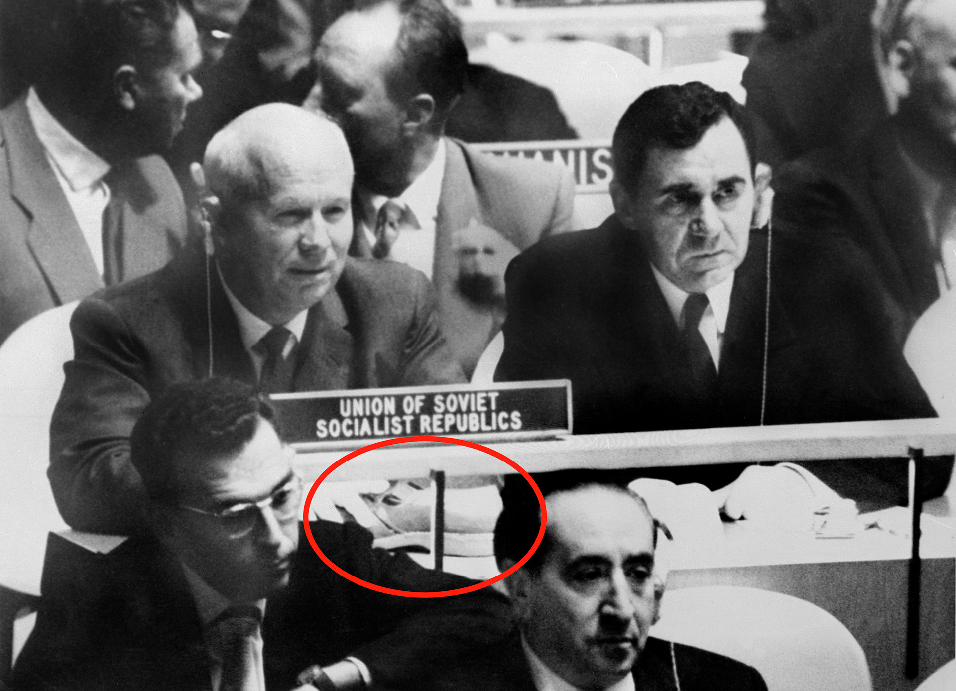 国連総会でのニキータ・フルシチョフとソ連のアンドレイ・グロムイコ外相（右）の実際の写真、 1960年10月12日。赤い丸で示されているのはフルシチョフの机の上に置いてある靴。