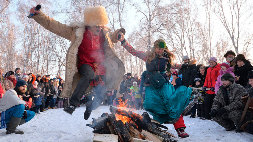 Participantes saltam sobre o fogo no Sviatki de 2017, festival de entretenimento e diversão na região de Tcheliabinsk.