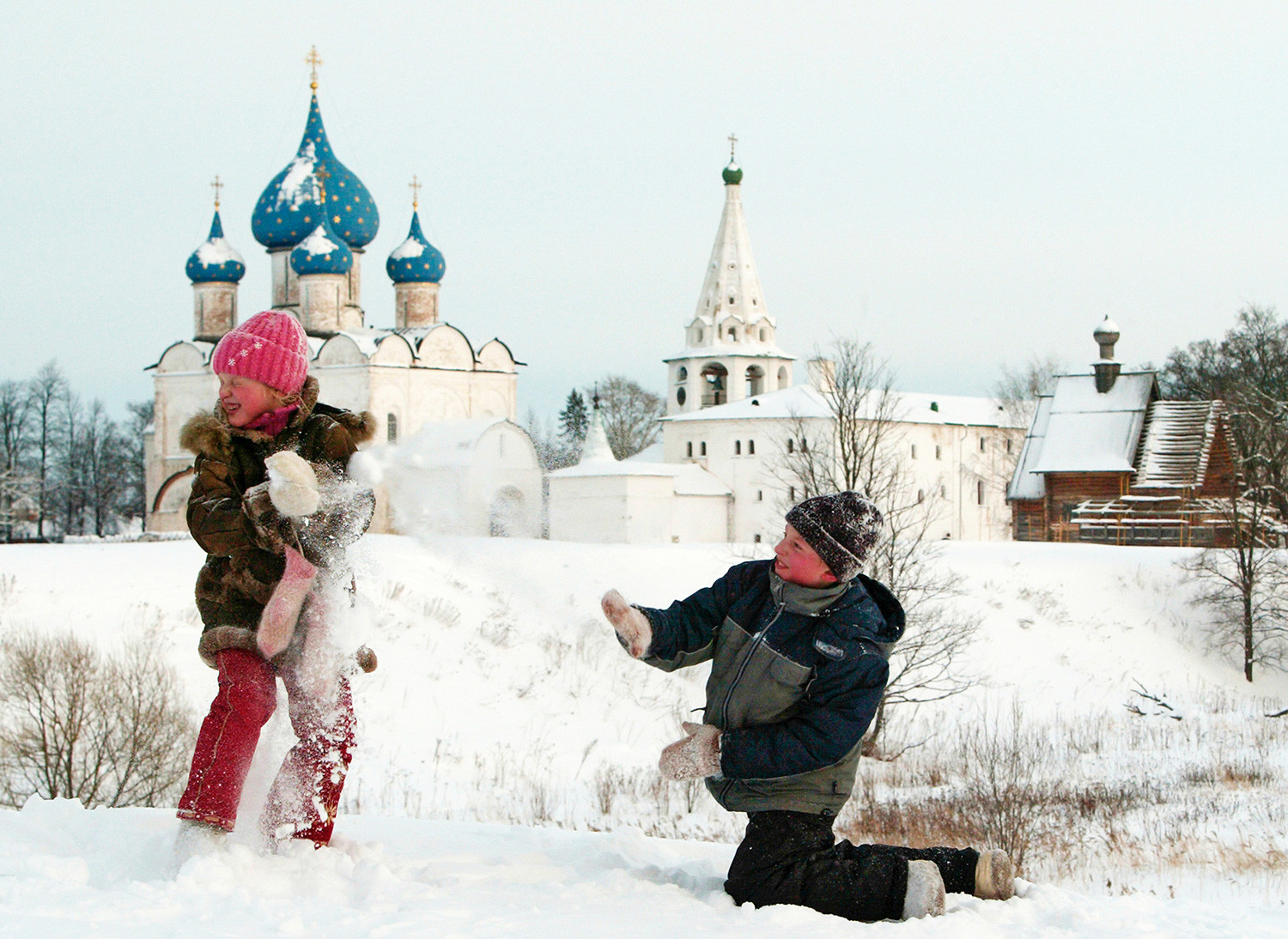 スーズダリのクレムリンの前で雪玉を投げている子供たち。