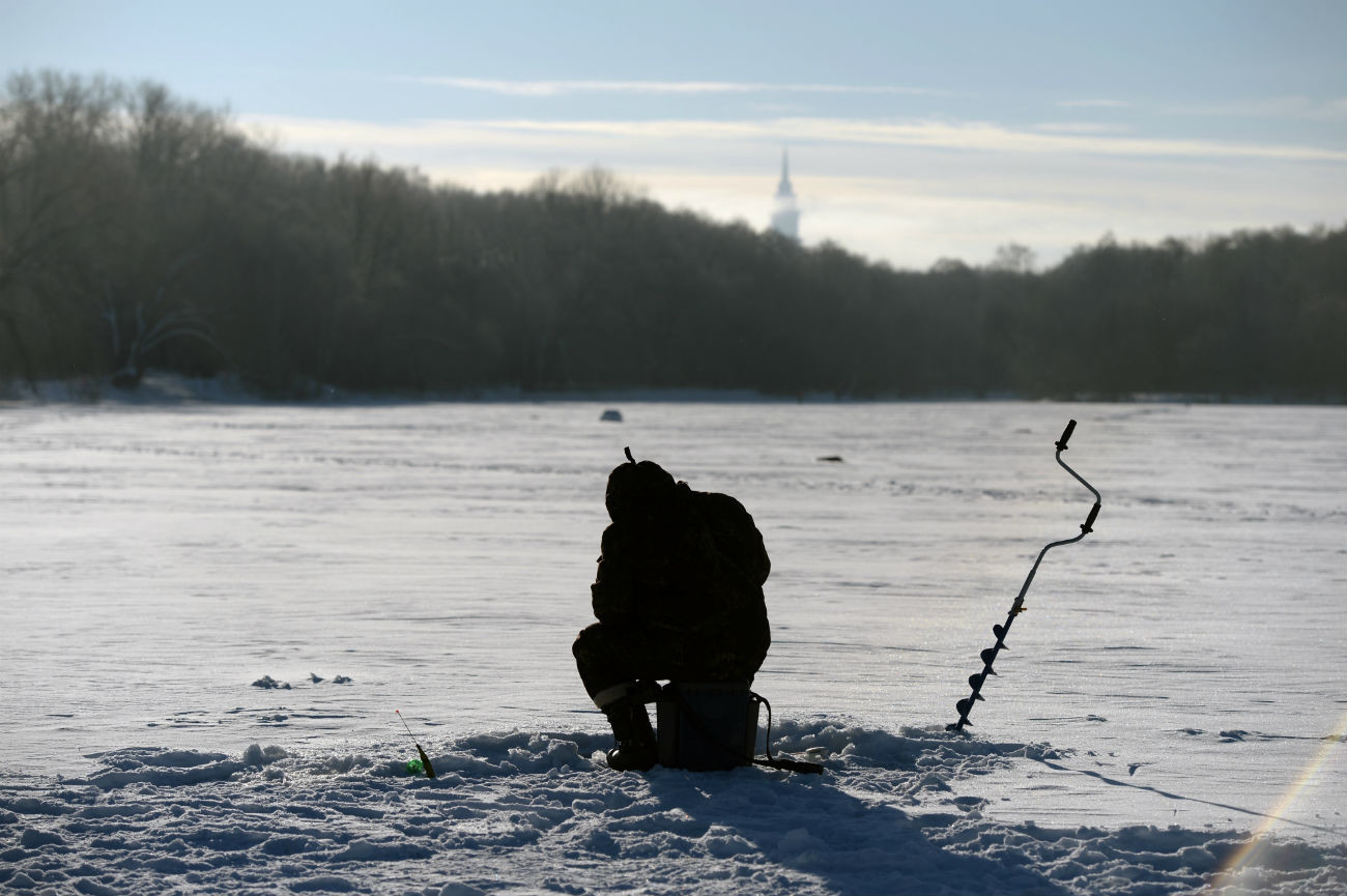Hombre pescando en el hielo en el estanque Bolshói Sadovi, en el parque de la Academia de Agricultura Timiriázev en Moscú.