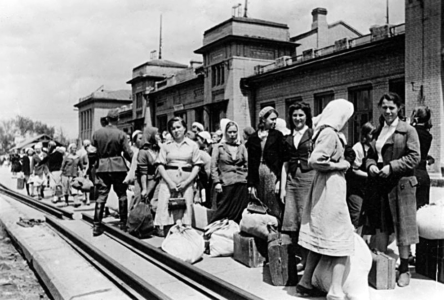 Kaum perempuan di stasiun kereta melambaikan tangan ke kereta ke Jerman (foto propaganda).