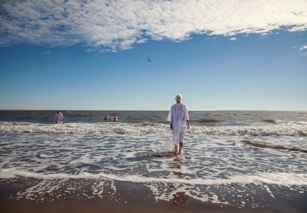 Women walking into the sea during an Epiphany ceremony in Brighton Beach, New York. January 19, 2013.