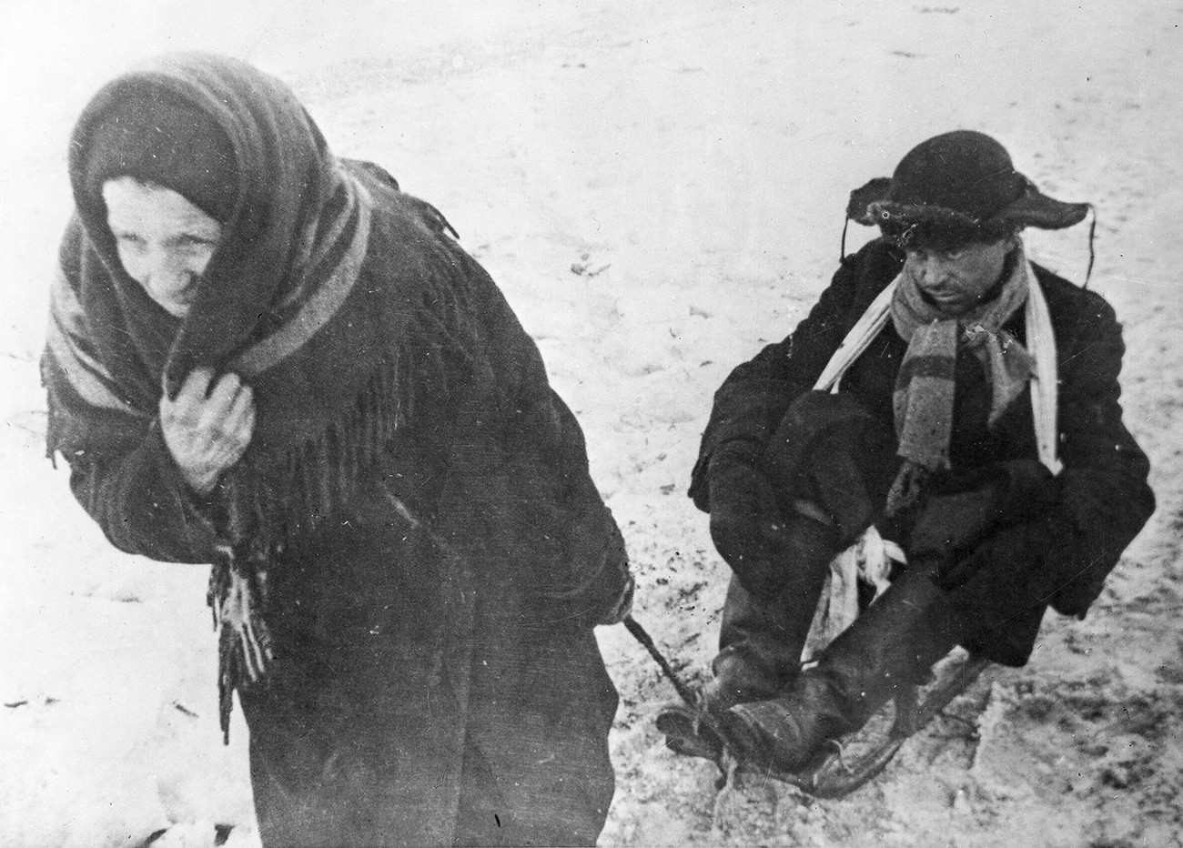 A woman dragging a sled with her malnourished husband, Leningrad, during the Siege