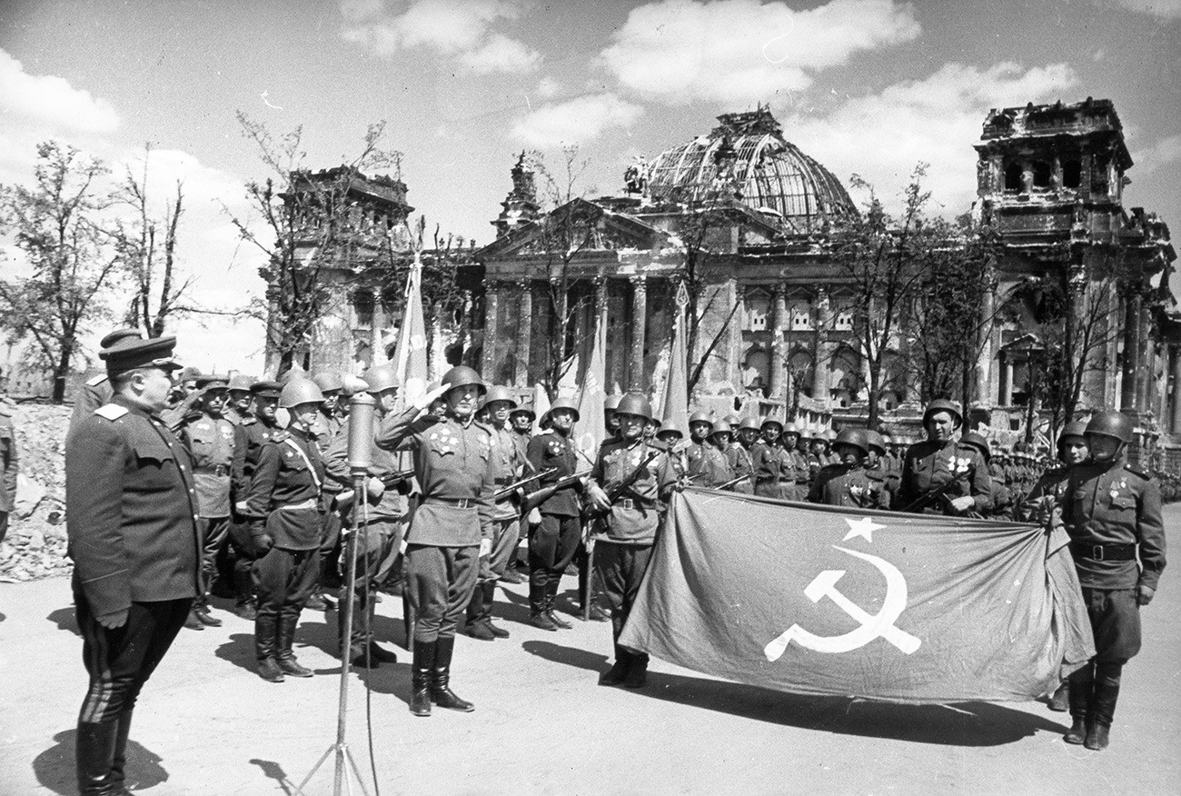 Червената армия празнува победата пред разрушената сграда на Райхстага, Берлин, Германия, май 1945 година.
