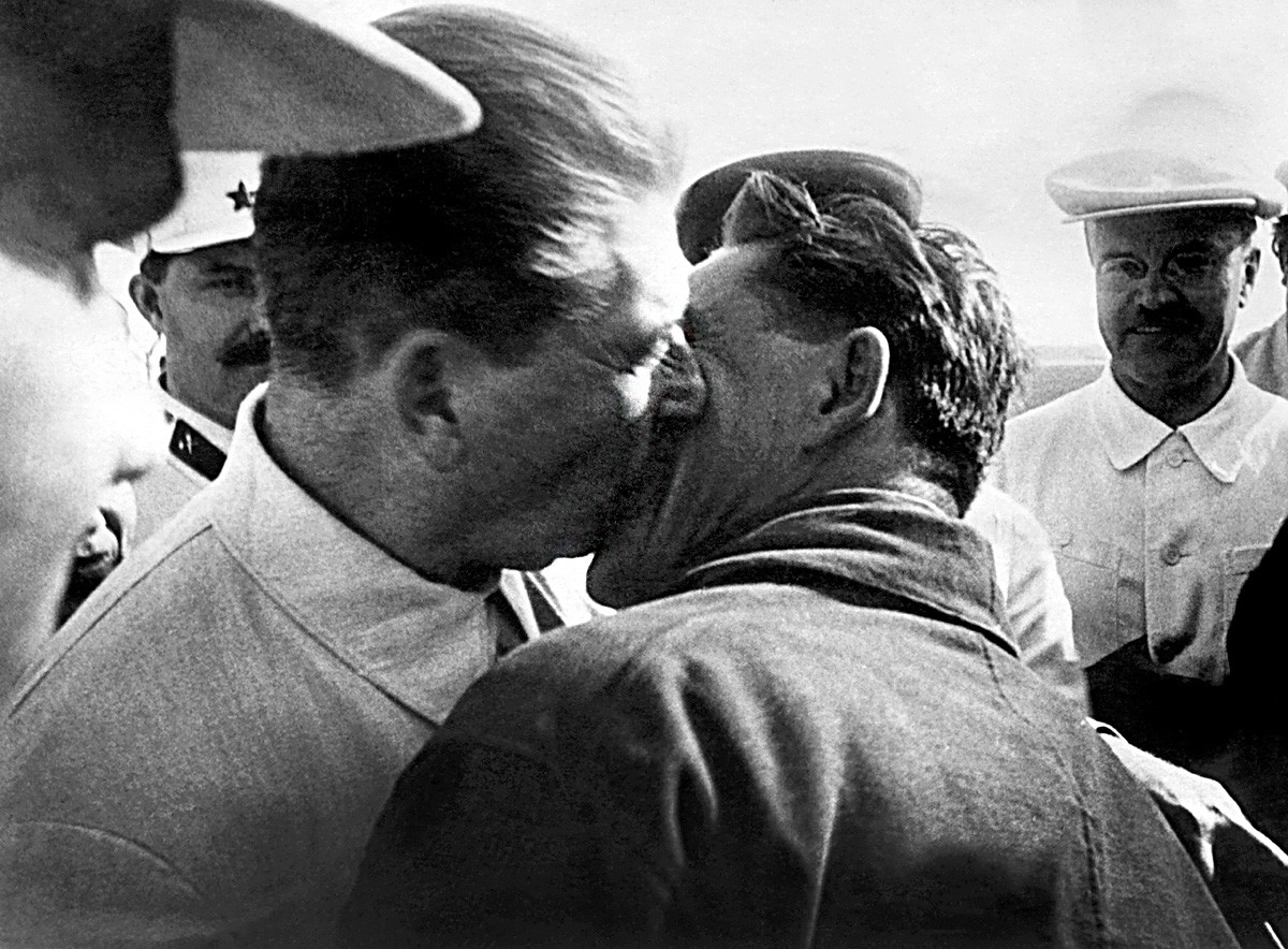 Joseph Stalin (L) kissing Polar pilot Vasily Molokov (R) at his return in Moscow with Otto Schmidt (not pictured) Arctic explorer on July 4, 1937