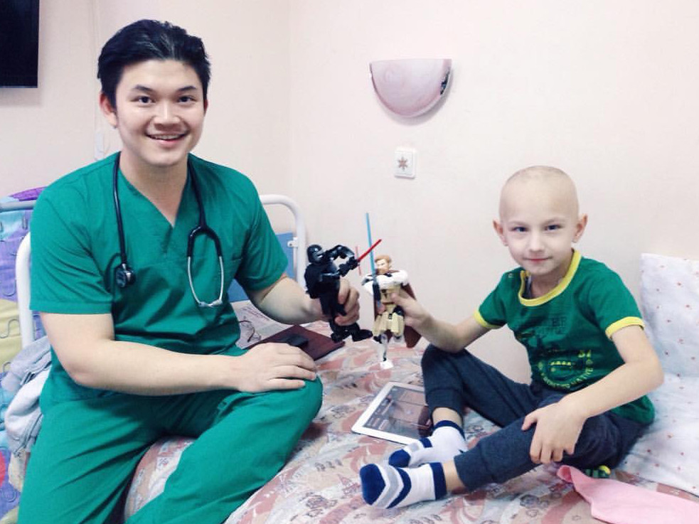 Steven Guntur bermain dengan seorang pasien yang akan menjalani kemoterapi di Rumah Sakit Anak Pemerintah di Sankt Petersburg.