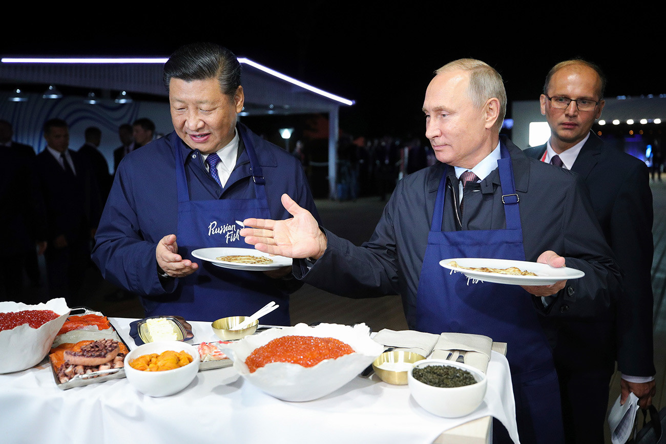 Vladimir Putin and Xi Jinping trying Russian food at the Eastern Economic Forum in 2018