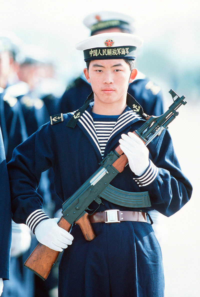 Un oficial chino con un AK-56 en las manos.