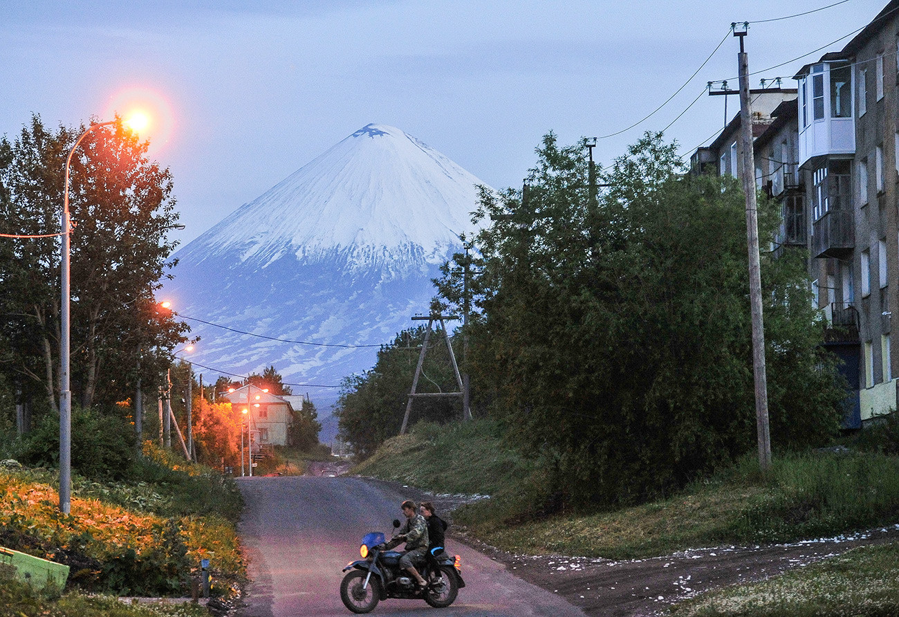 Residents of Klyuchy village in Kamchatka. Background: Klyuchevskaya Sopka.