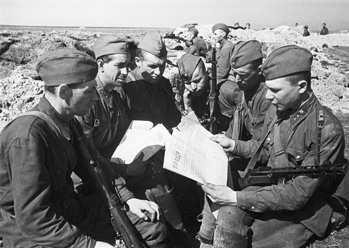 Soldados do Exército Vermelho lendo Pravda nas trincheiras em 1942, durante a Grande Guerra Patriótica