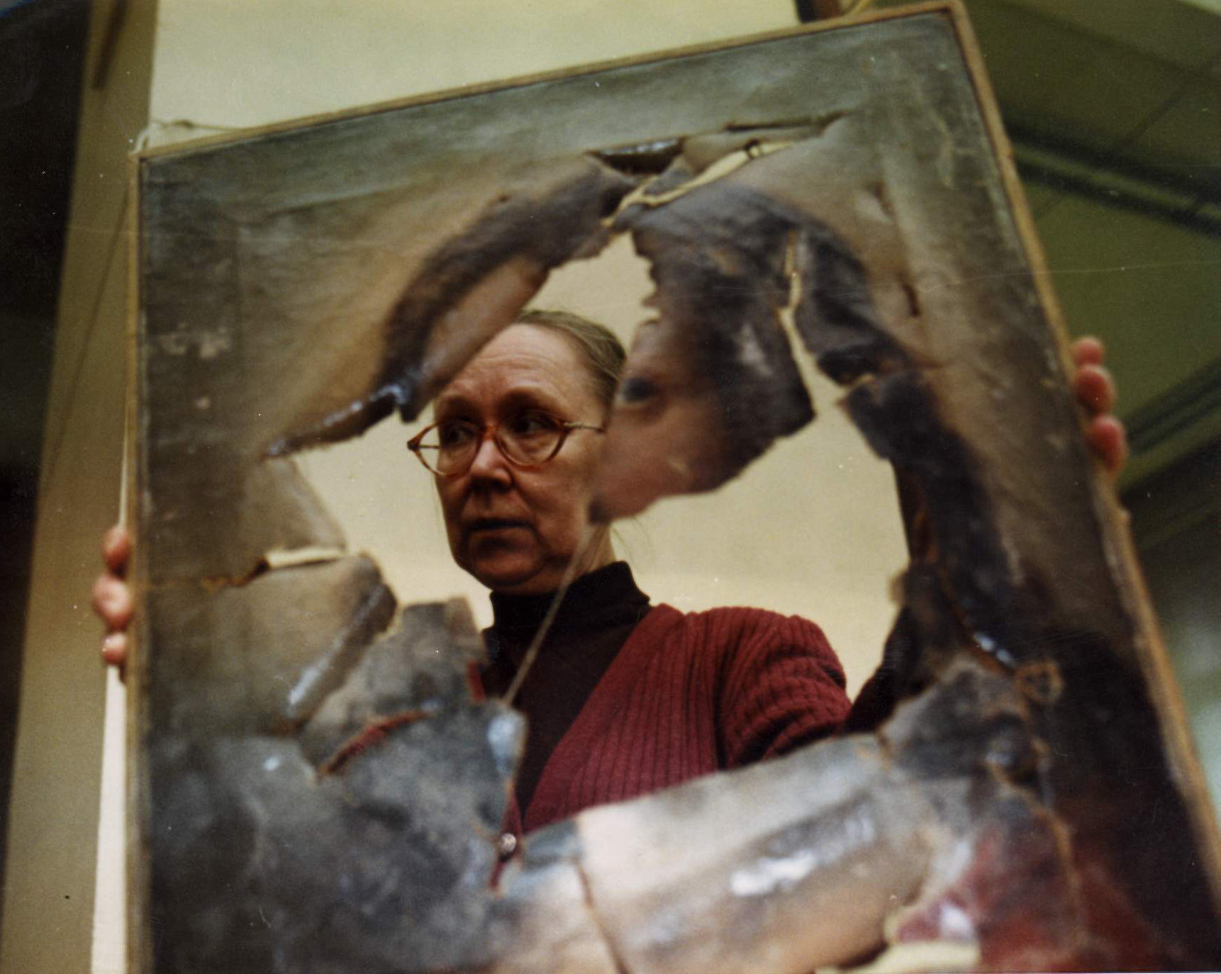 La restauratrice N. Kochkina et une toile abîmée pendant les guerres de Tchétchénie.
