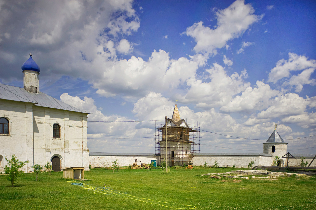 Luzhetsky Monastery. From left: Refectory Church of the Presentation, north wall, North Gate, northeast corner tower. Right foreground: foundation of original Church of St. John Climacus over grave of St. Ferapont. July 5, 2015.