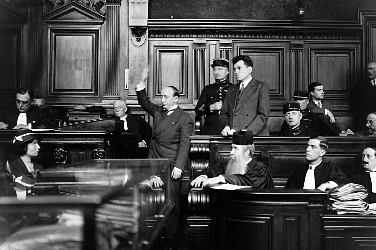 Pariz, Francuska 25. srpnja 1932. Pavel Gorgulov, ubojica francuskog predsjednika Paola Doumera, na optuženičkoj klupi sa svojim odvjetnikom i svjedokom koji polaže prisegu prije davanja izjave.