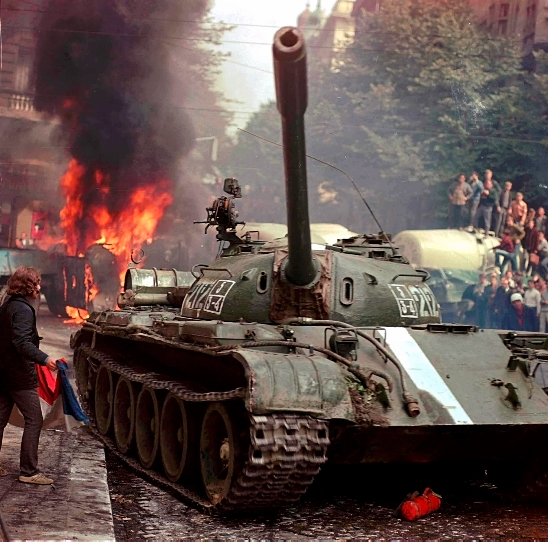 1968年8月。チェコスロバキアのラジオ、プラハ本局付近で間に合わせのバリケードを通ろうとしているソ連の戦車。