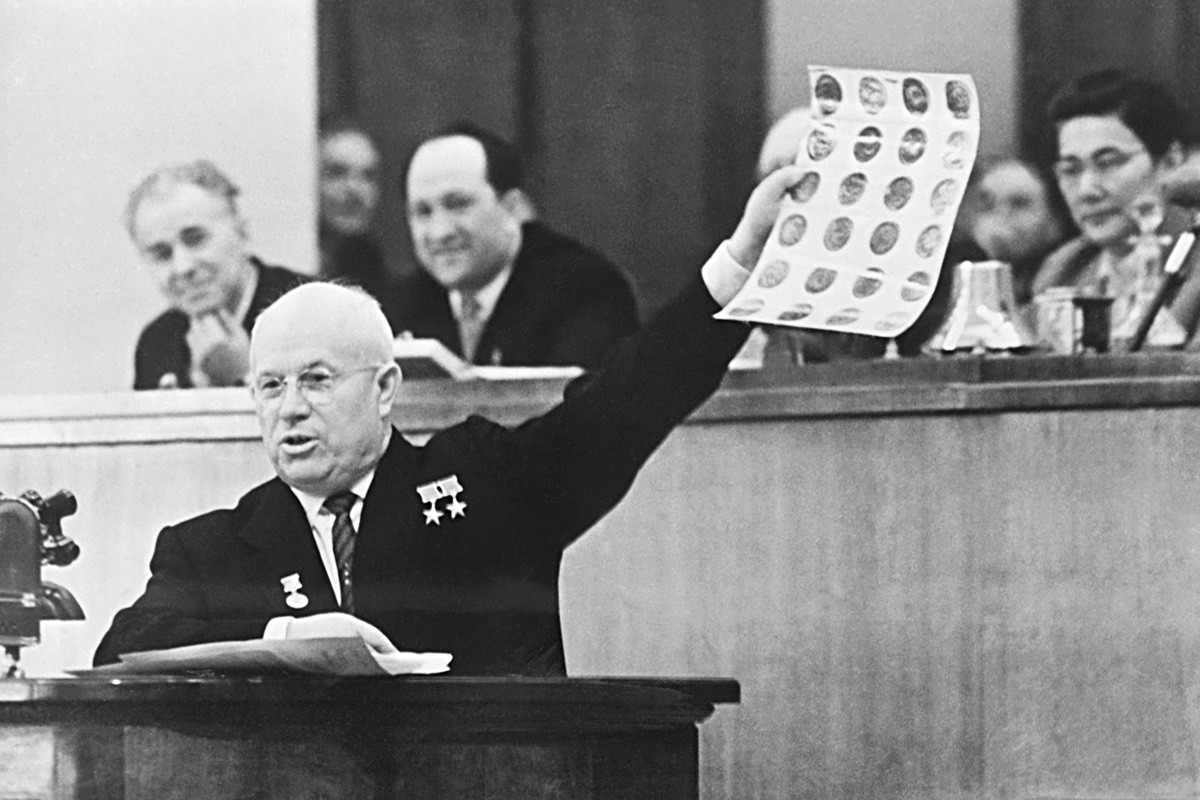 Appearing before the Soviet Parliament, Soviet Premier Nikita Khrushchev holds aloft photos which he identified as views of Military and Industrial targets taken by downed American pilot Francis Powers. 