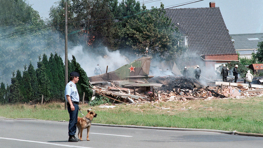The tail of a Soviet MIG-23 combat plane rises from the rubble after it crashed into a house in Wevelgem near the French border, July 4, 1989. 