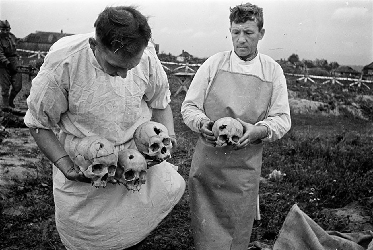 Soviet forensic archaeologists studying dead bodies found in a concentration camp, 1943.