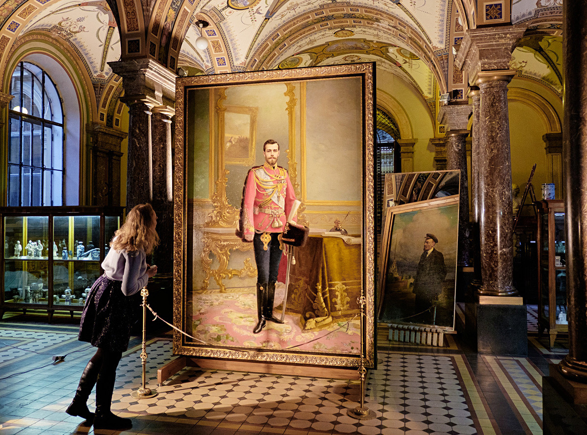 A woman glancing at the portrait of Nicholas II, the last tsar/czar of Russia.