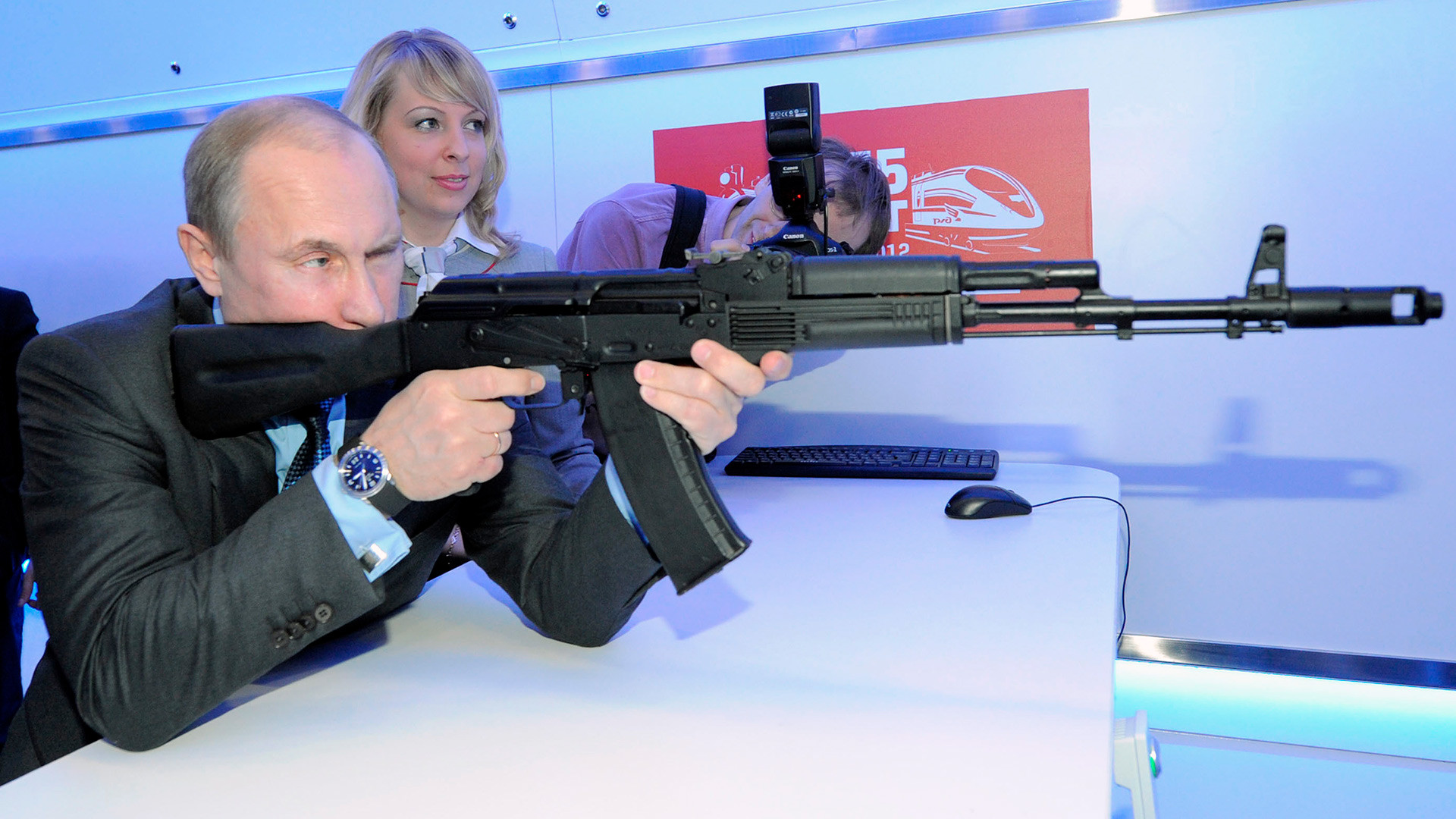 Руският президент Владимир Путин тества АК-74 по време на военна изложба в Русия.
