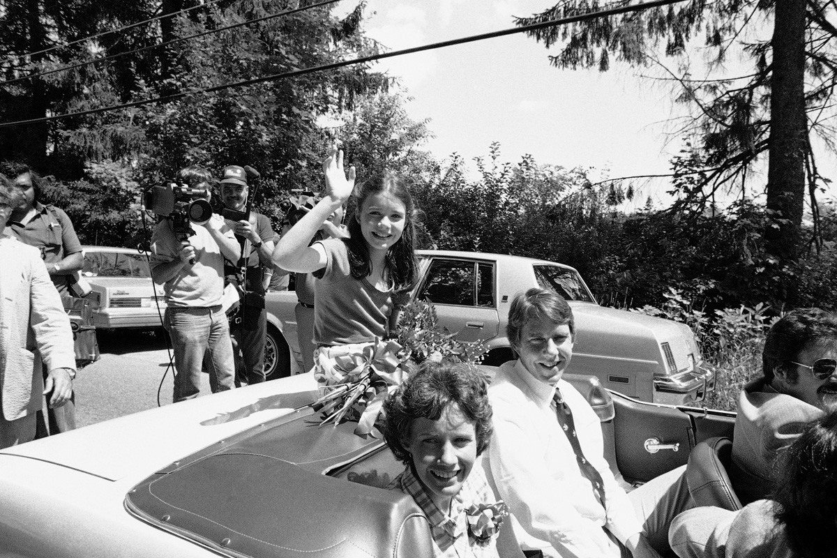 Samantha Smith acena do carro enquanto sua cidade natal a recebe de volta da União Soviética, em 23 de julho de 1983, em Manchester, Maine. A mãe de Samantha, Jane, e o pai, Arthur, estão sentados ao lado dela.