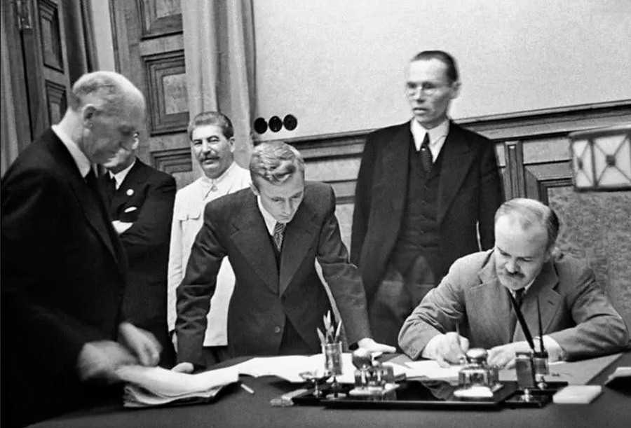 Le commissaire du peuple des affaires étrangères de l'URSS Viatcheslav Molotov signe un traité portant sur l'amitié et les frontières entre l'URSS et l'Allemagne. Parmi les personnes présentes : Staline, V. Pavlov, traducteur du ministère des Affaires étrangères.