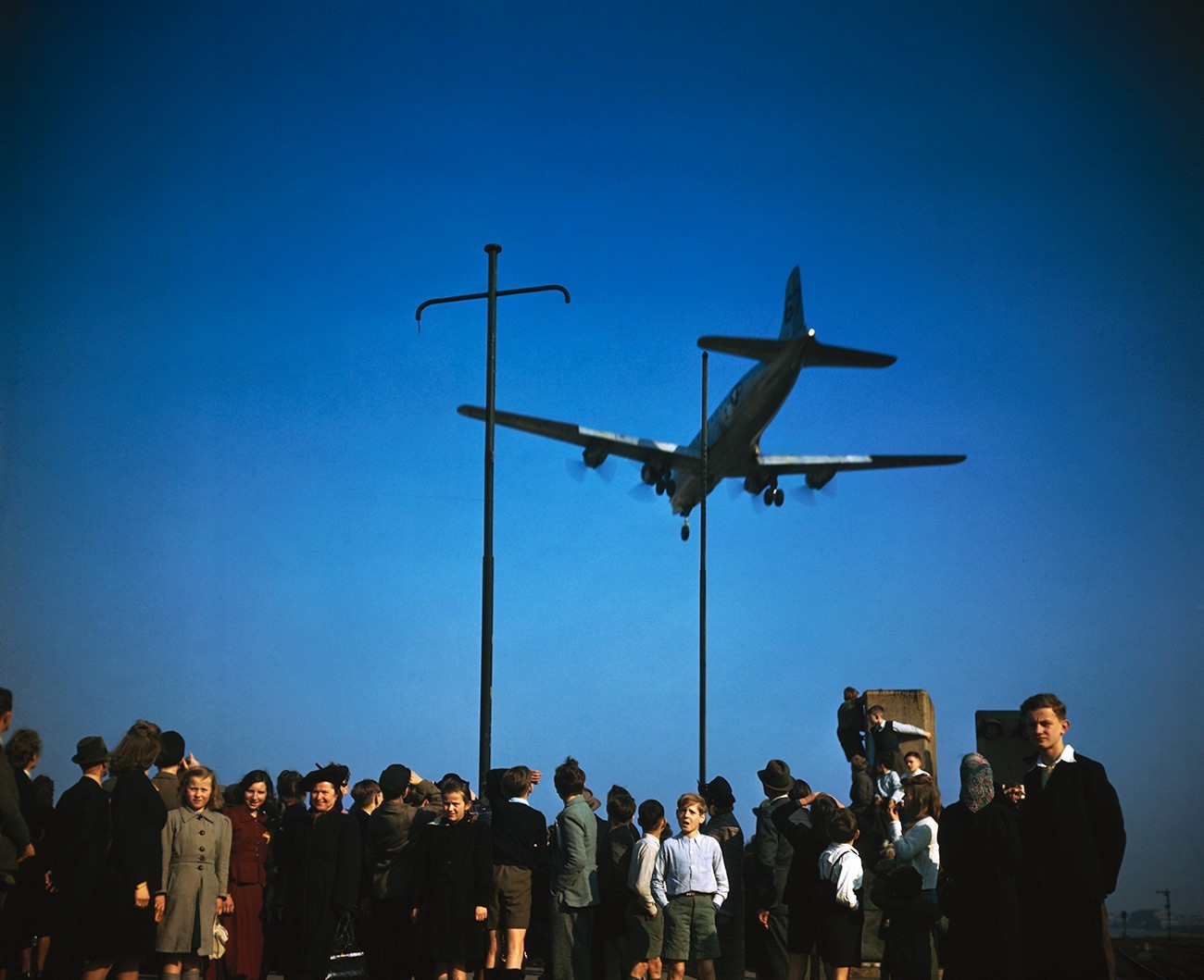 Berlinčani opazujejo oskrbovalna letala med pristajanjem v času sovjetske blokade Berlina.